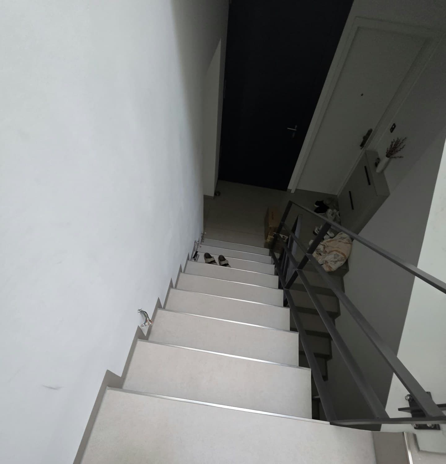 Treppe mit hellen gefliesten Stufen und Metallkanten, von oben